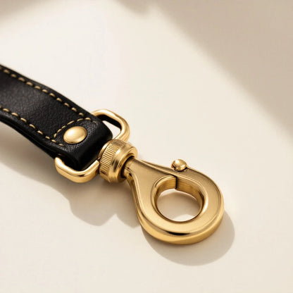 Larkwell The Safe Tether dog seat belt strap with black leather, gold stitching, and a solid brass screw-lock hook.
